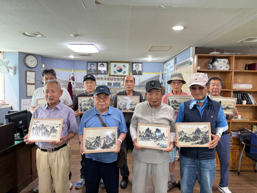 3. 지난 23일 신천지자원봉사단 부산서부지부가 월남전참전자회 사하구지회를 방문하여 '맥박으로 그린 AI수묵화'를 전달한 가운데 참전용사들과 기념촬영을 하고 있다..jpg