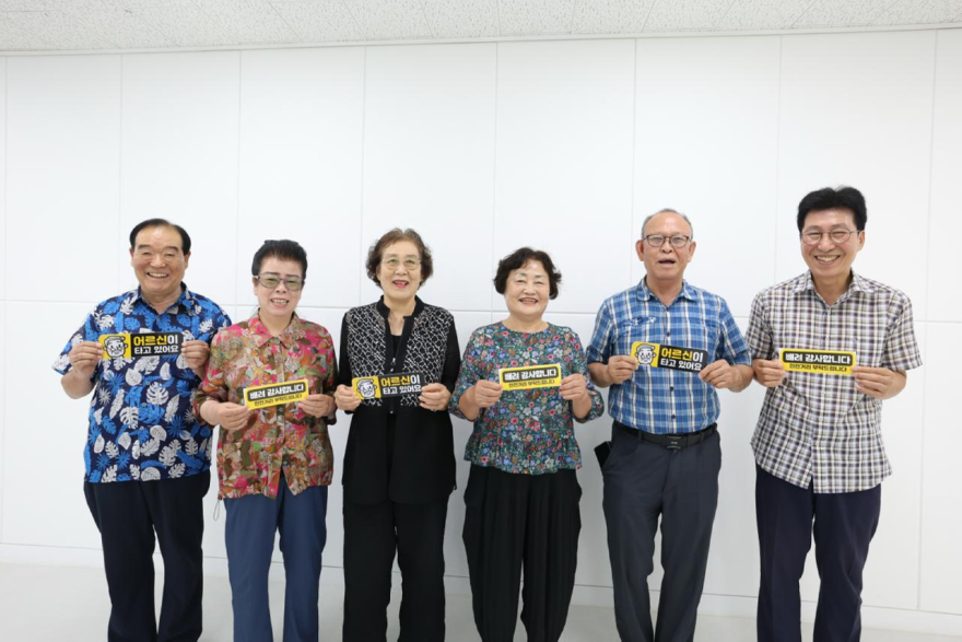 1 어르신들이 안전한 도로 환경 조성을 돕는 '어르신이 타고 있어요', '배려 감사합니다' 차량용 자석 스티커를 들고 환하게 미소 짓고 있다..jpg